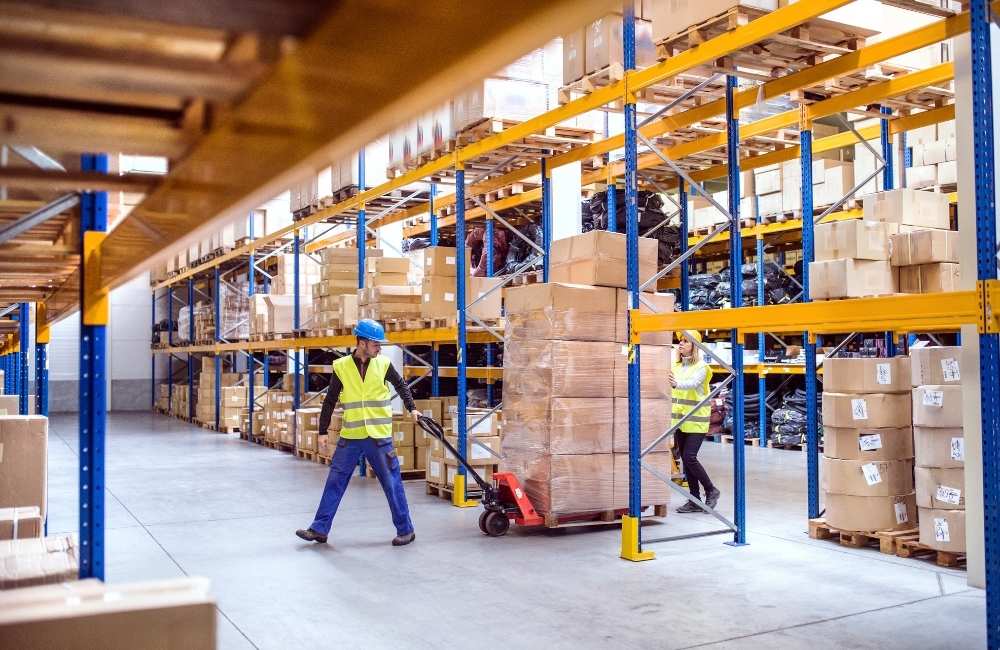 Personnel pulling a cart with loads of boxes